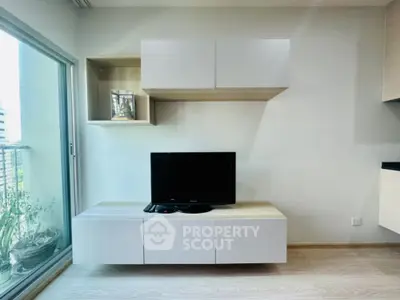 Sleek modern living room with minimalist design, featuring floating shelves, a low-profile TV stand, and ample natural light from the large window.