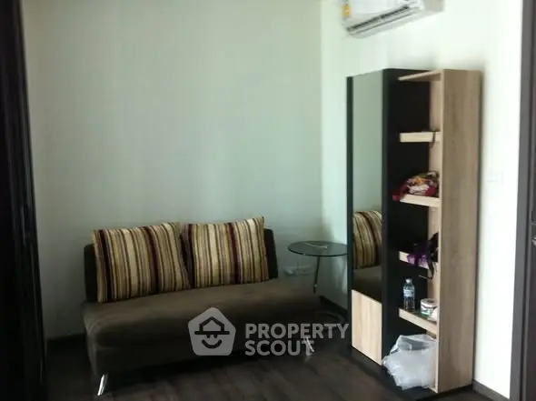 Cozy living room with modern sofa and stylish shelving unit, perfect for urban living.