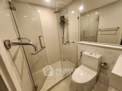Modern bathroom with glass shower enclosure and sleek fixtures