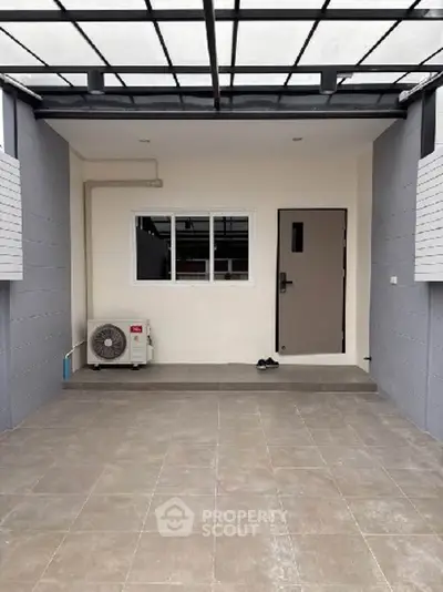 Modern home entrance with covered parking and air conditioning unit