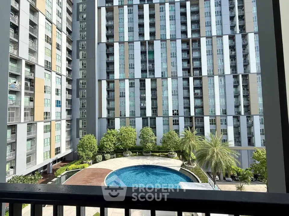 Modern high-rise building with pool view and lush greenery