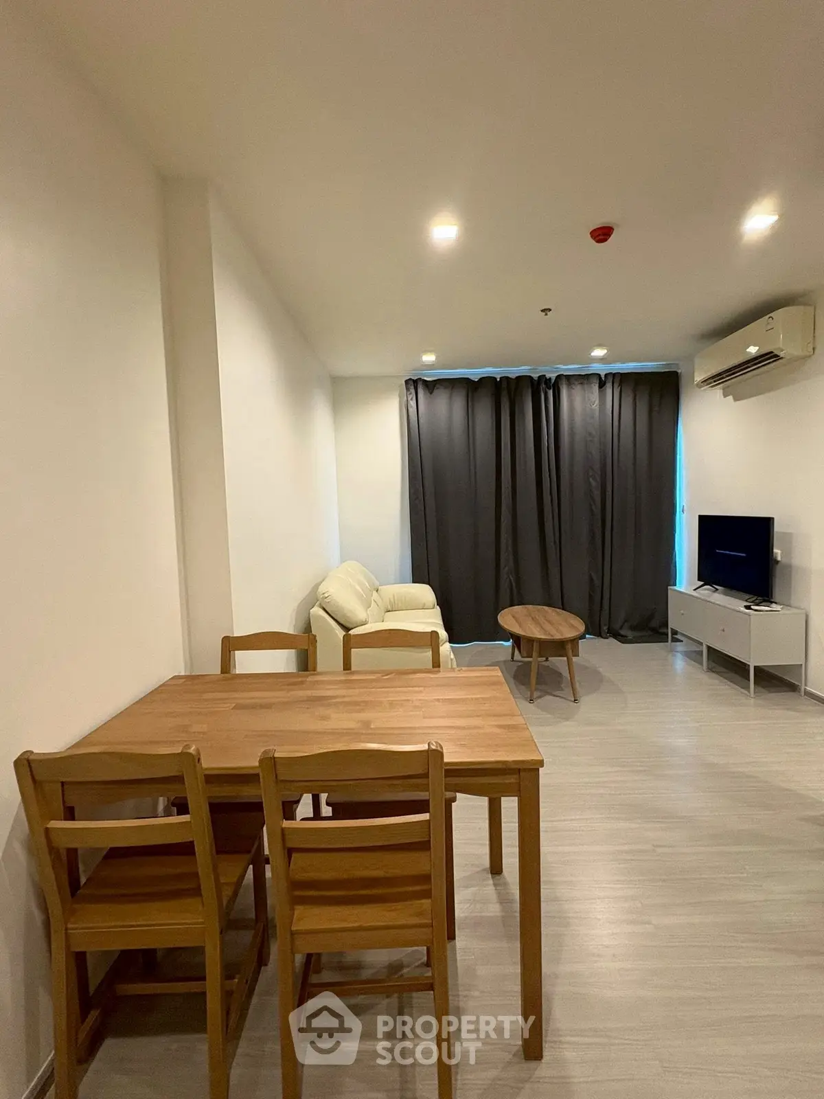 Modern living room with wooden dining set and cozy seating area, perfect for relaxation.