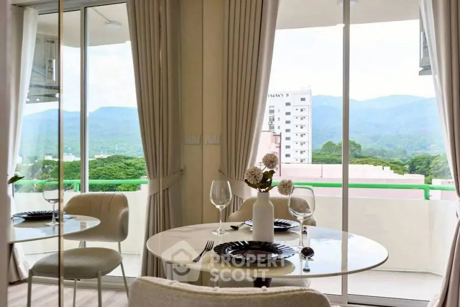 Chic dining area with mountain view, elegant table setting, and floor-to-ceiling windows.