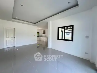 Spacious modern living room with sleek tile flooring and open kitchen layout