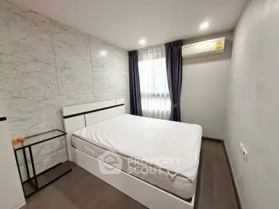 Modern minimalist bedroom with marble accent wall and natural light