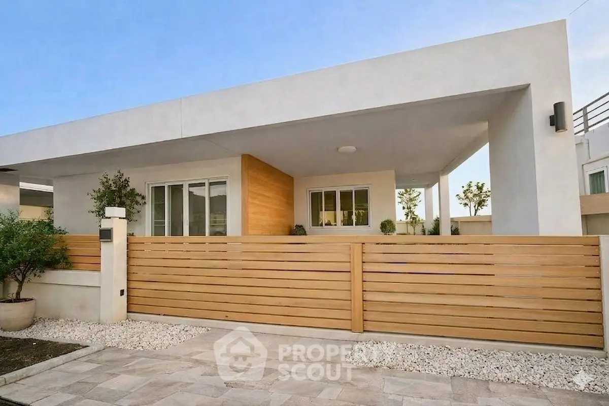 Modern single-story home with sleek wooden fence and minimalist design.