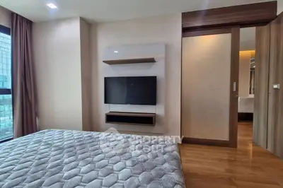 Modern bedroom with wall-mounted TV and sliding wooden door