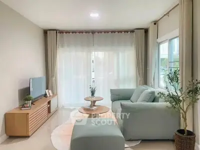 Charming living room with cozy sofa, stylish decor, and abundant natural light from large windows.