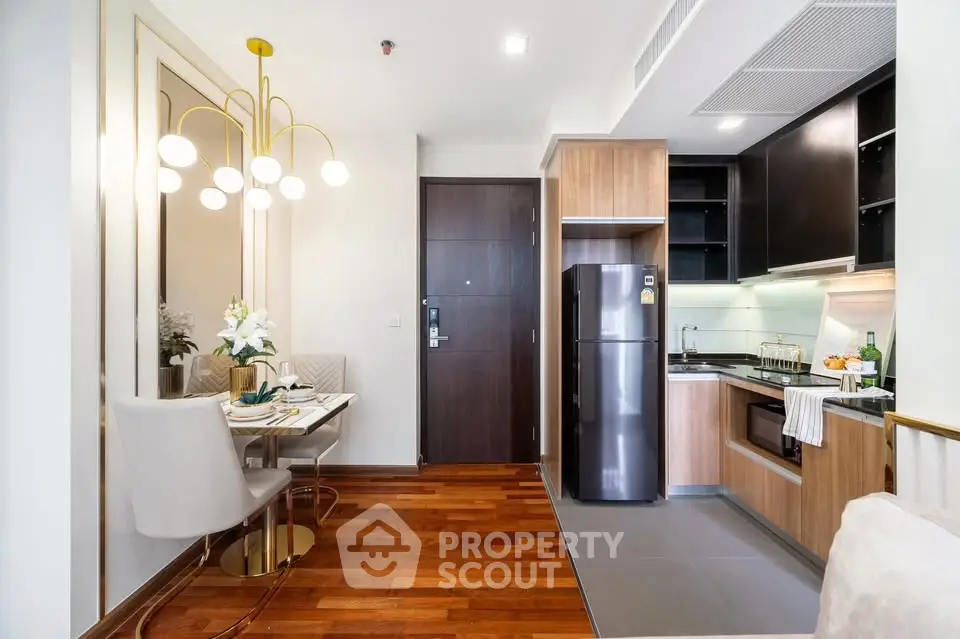 Modern kitchen and dining area with wooden flooring and elegant lighting