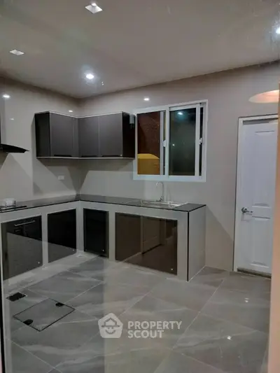 Modern kitchen with sleek cabinetry and tiled flooring