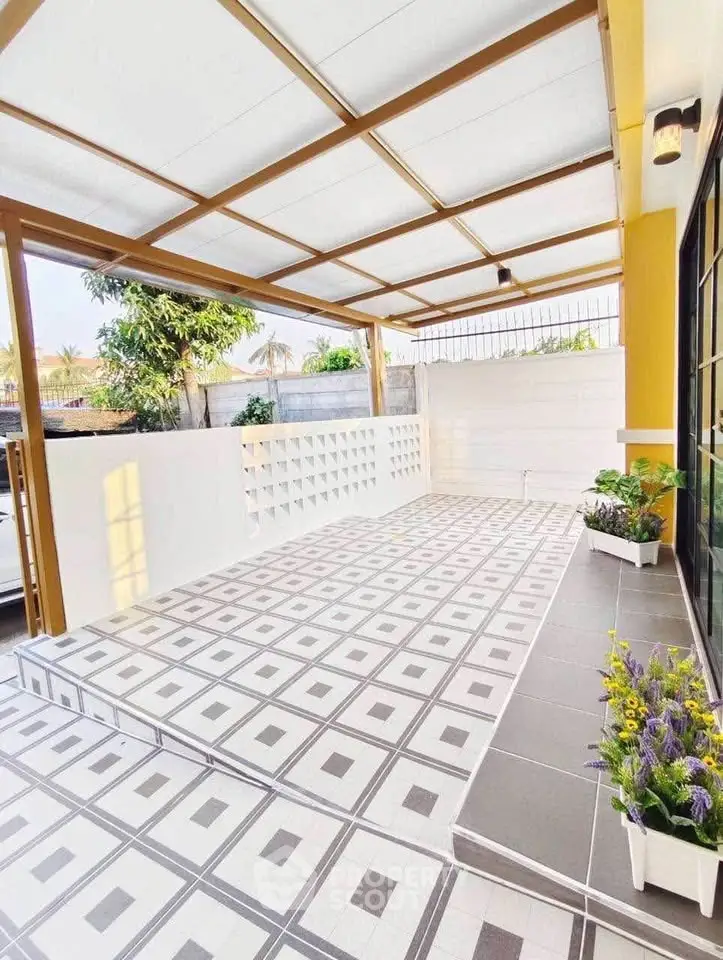Spacious tiled patio with modern design and decorative plants, perfect for outdoor relaxation.