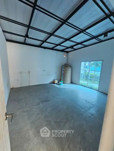 Spacious empty room with large windows and modern ceiling design, perfect for customization.