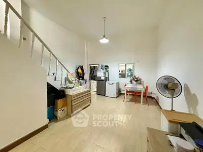 Spacious open-plan living area with dining table and staircase, ideal for family gatherings.