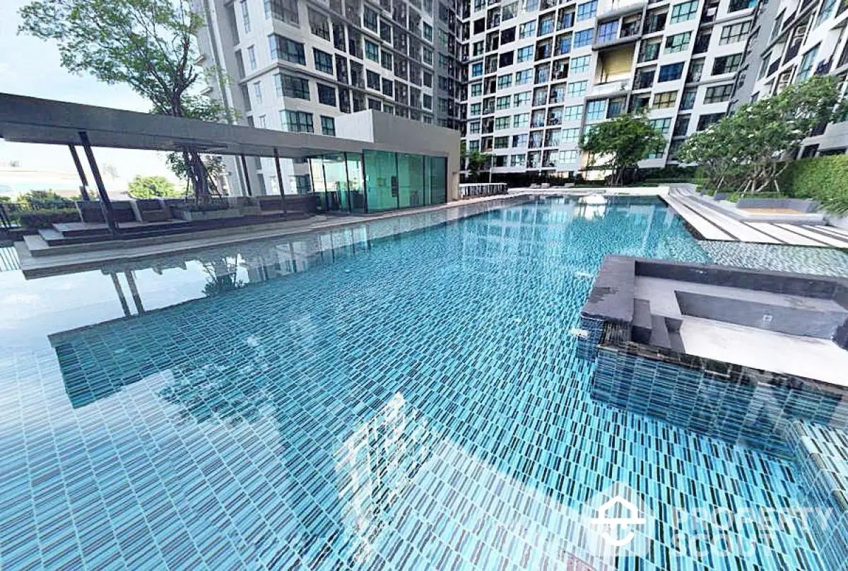 Luxurious modern apartment complex with stunning swimming pool and sleek architectural design.