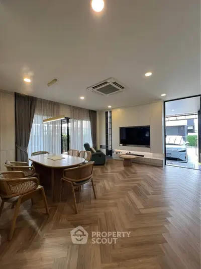 Spacious modern living room with elegant wooden flooring and stylish furniture.