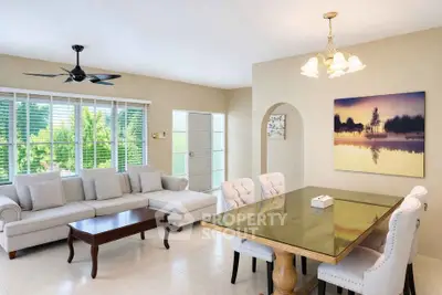 Elegant living room with large windows and stylish dining area, perfect for modern family living.