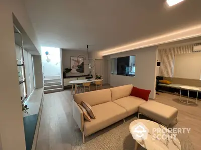 Modern living room with stylish furniture and open layout, featuring a cozy sofa and elegant decor.