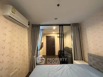 Cozy bedroom with modern air conditioning and sliding glass doors leading to a stylish living area.
