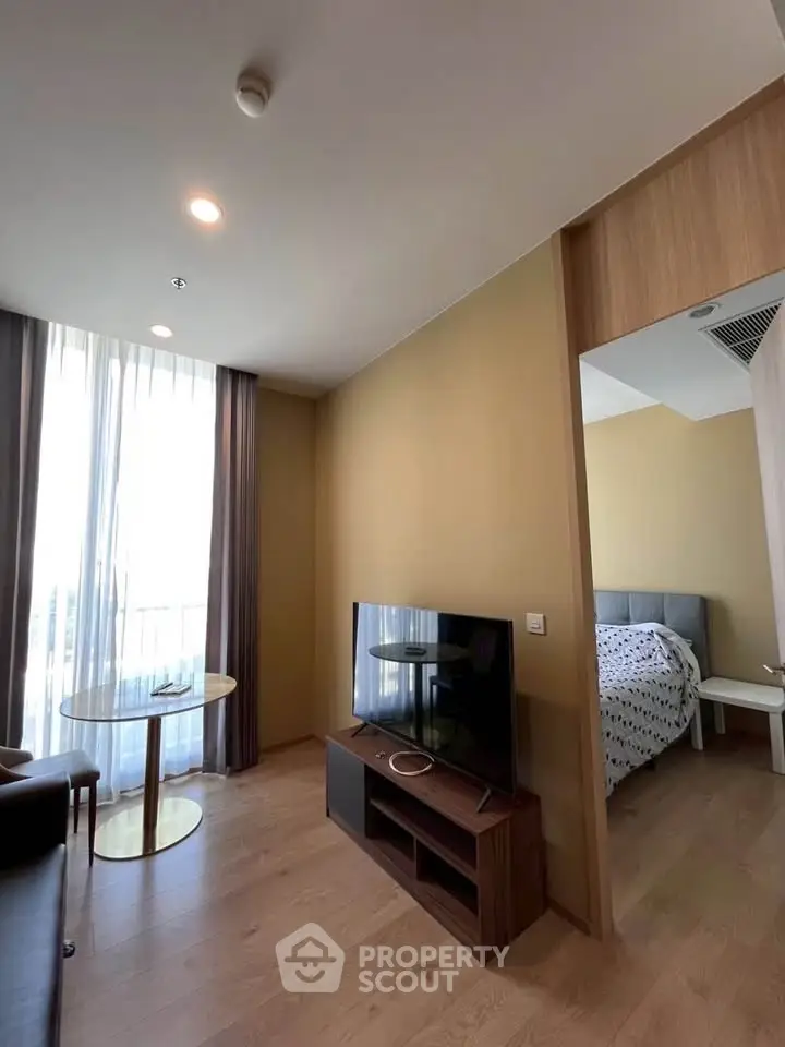 Modern living room with TV and cozy bedroom in a stylish apartment