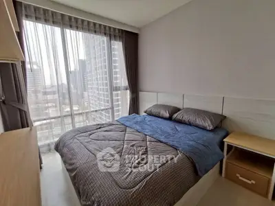 Modern bedroom with city view, featuring cozy bedding and natural light.