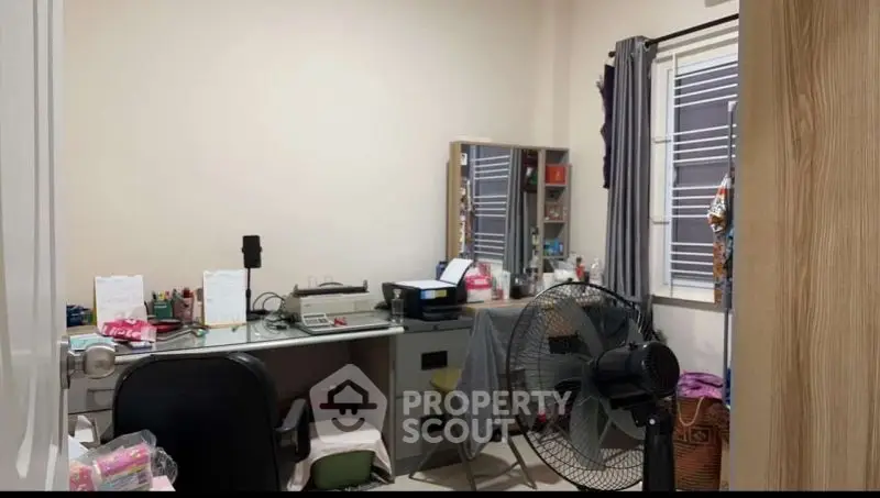 Cozy study room with desk, fan, and ample storage space