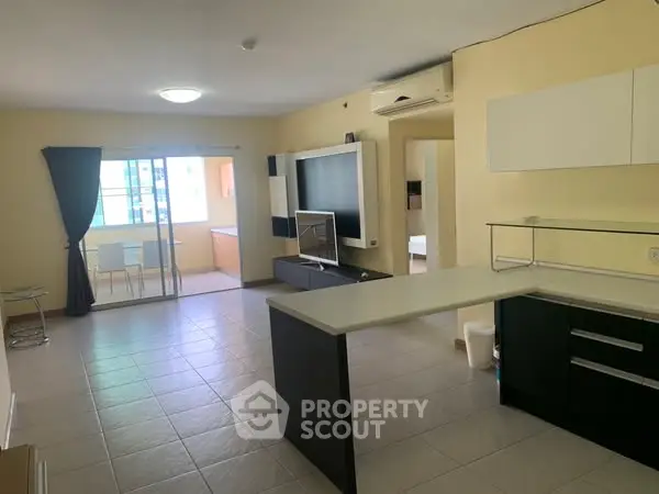 Spacious open-plan living room with modern kitchen and ample natural light.