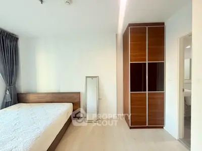Spacious bedroom with modern wooden wardrobe and cozy bed in bright apartment