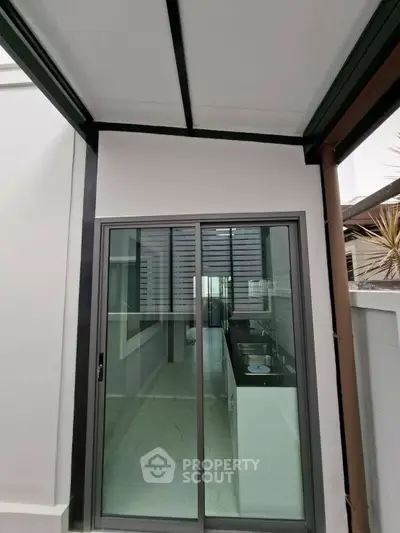 Modern kitchen with sleek design and sliding glass doors leading to outdoor space.