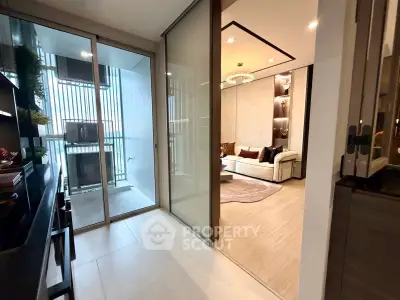 Modern living room with glass doors leading to a balcony, featuring stylish decor and ample natural light.