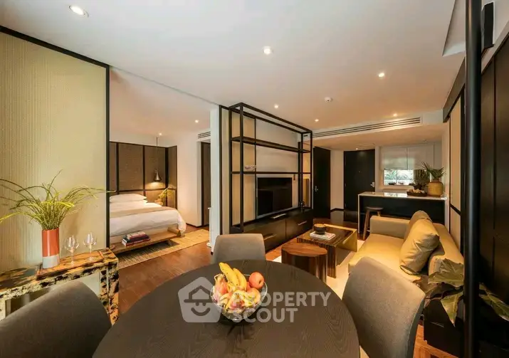 Luxurious open-plan living room with modern decor and cozy bedroom view.