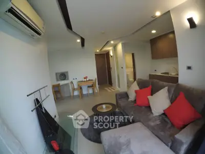 Modern living room with cozy sofa, dining area, and sleek kitchen in open layout apartment.