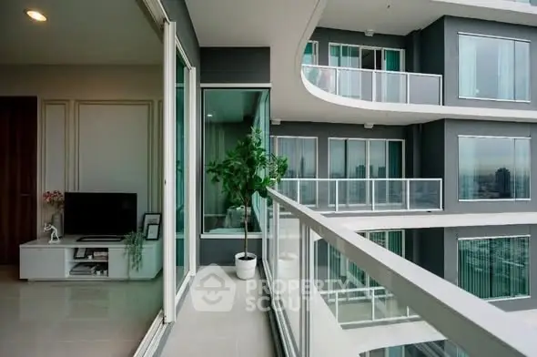 Modern apartment with spacious balcony and stunning city view, featuring sleek glass railings and contemporary design.
