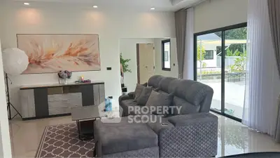 Spacious modern living room with elegant decor and large sliding glass doors opening to a patio.