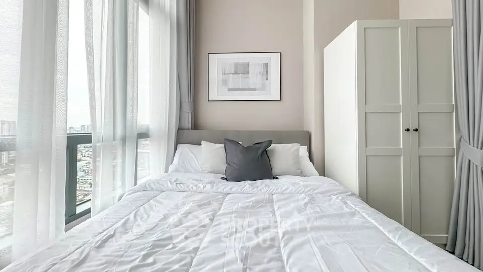 Bright and cozy bedroom with large window and modern decor in a high-rise apartment.