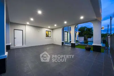 Spacious covered patio with modern lighting and garden view