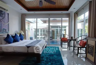 Luxurious bedroom with pool view, featuring elegant decor and abundant natural light.