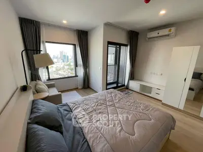 Modern bedroom with city view, cozy decor, and ample natural light