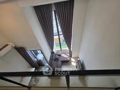Stunning high-ceiling living room with floor-to-ceiling windows and modern decor.