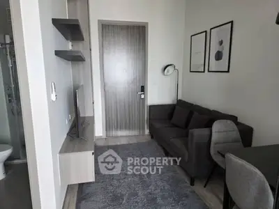 Modern living room with sleek furniture and stylish decor in a compact apartment setting.