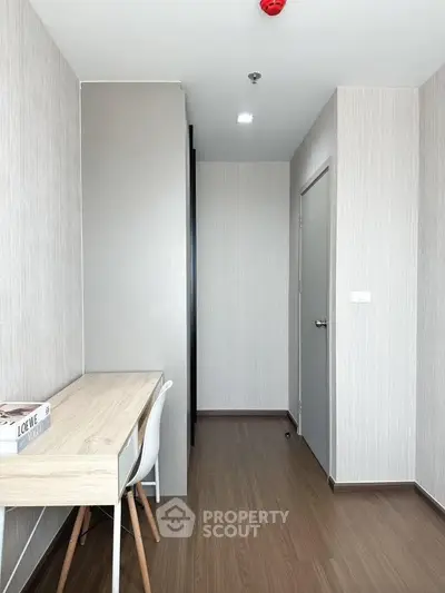 Modern study room with sleek wooden desk and chair, featuring minimalist design and neutral tones.