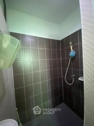 Modern bathroom with sleek dark tiles and shower area