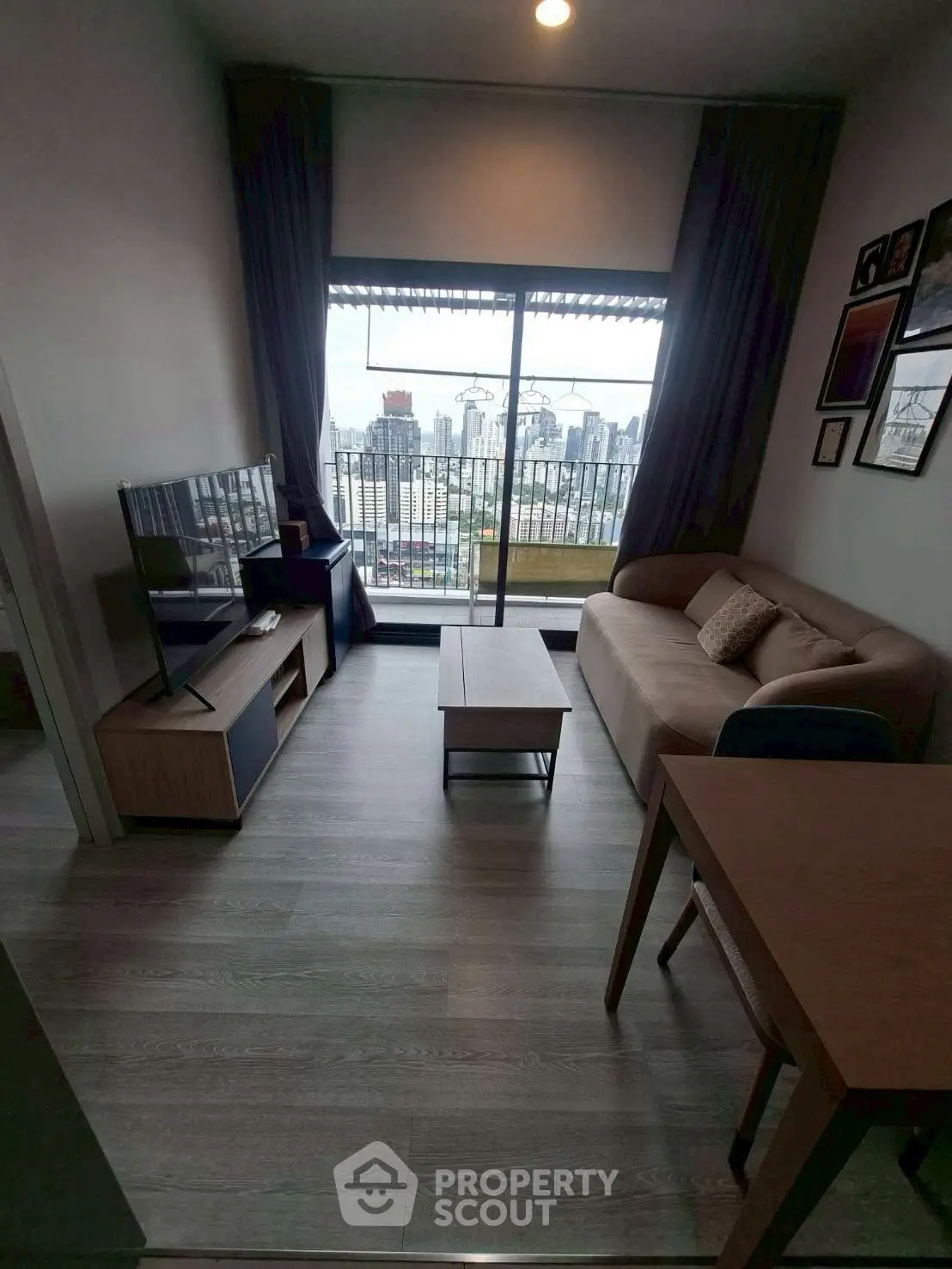 Modern living room with city view, stylish furniture, and large window balcony access.