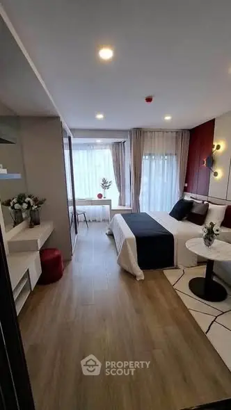 Modern bedroom with elegant decor and large windows offering natural light