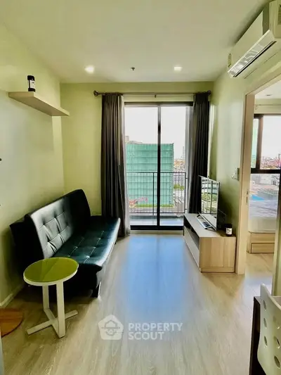 Modern living room with balcony view, sleek furniture, and natural light.