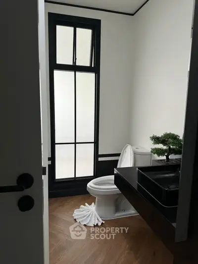 Modern bathroom with sleek black fixtures and large window