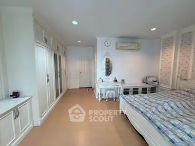 Spacious bedroom with elegant decor and ample storage in a modern home.