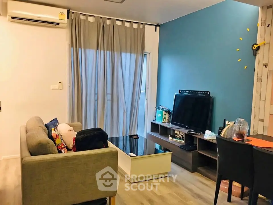 Modern living room with stylish decor and entertainment setup, featuring a cozy sofa and vibrant wall accents.