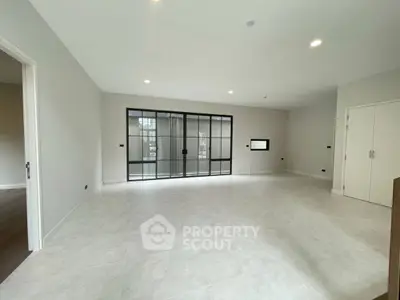 Spacious modern living room with large windows and elegant flooring