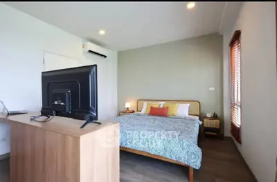 Spacious bedroom with modern decor and natural light, featuring a comfortable bed and stylish furnishings.
