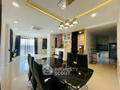 Luxurious open-plan living and dining area with modern decor and elegant lighting.